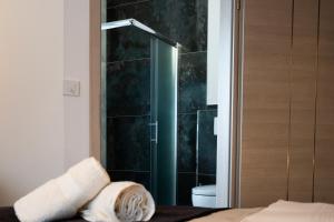 łazienka z prysznicem oraz łóżko z ręcznikami w obiekcie Grand Hotel w mieście Soltau