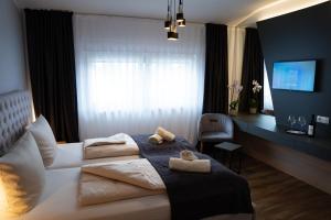 1 dormitorio con 1 cama con 2 toallas en Grand Hotel, en Soltau