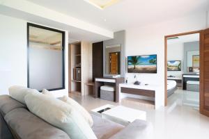 sala de estar con sofá y espejo en Paripas Patong Resort - SHA Extra Plus, en Patong Beach