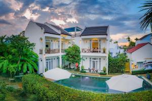 an exterior view of a house with a swimming pool at La Uy Villa in Hoi An