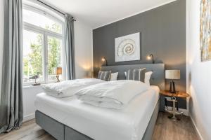 a bedroom with a large white bed with a window at NEU! Exklusives Apartment Turmkoje im Herzen Westerlands in Westerland (Sylt)
