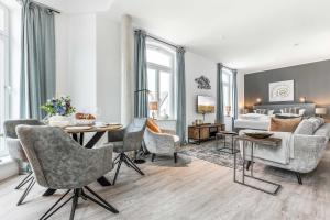 uma sala de estar com uma mesa e cadeiras e um sofá em NEU! Exklusives Apartment Turmkoje im Herzen Westerlands em Westerland