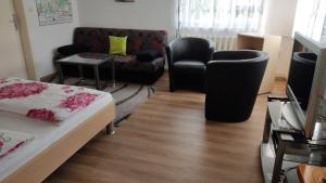 uma sala de estar com um sofá e uma cadeira em Ferienwohnung Schaarschmidt em Kurort Altenberg