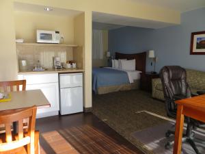 a hotel room with a bed and a table and chairs at Coronet Motel in Palo Alto +9 photos