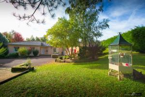 a yard with a bird cage in the grass at LE BOUILLARY in Cussac