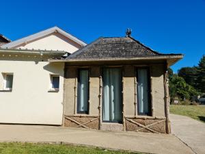 una pequeña casa blanca con ventanas tapiadas en Cabane des molieres, en Saint-Dié-des-Vosges