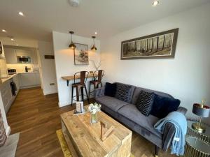 a living room with a couch and a table at Maple Cove in Rawtenstall