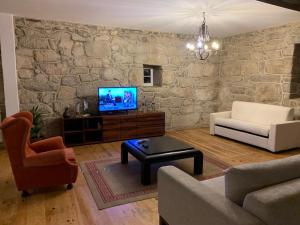 uma sala de estar com uma parede de pedra em Quinta Viela Principal em Viseu