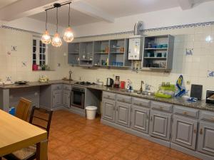 a large kitchen with gray cabinets and a table at Quinta Viela Principal in Viseu