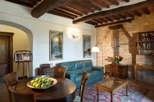 een woonkamer met een blauwe bank en een tafel bij B&B L'orto Delle Terme in Bagno Vignoni