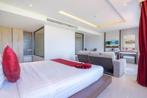 sypialnia z dużym białym łóżkiem i biurkiem w obiekcie Paripas Patong Resort - SHA Extra Plus w Patong Beach