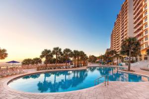 duży basen z palmami i budynek w obiekcie Club Wyndham Ocean Walk w mieście Daytona Beach