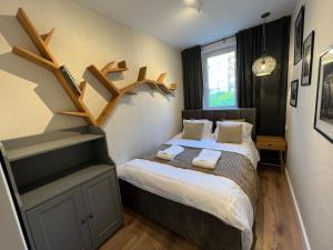 a small bedroom with a bed with wooden shelves at Apartament Dzika Natura in Szczawnica