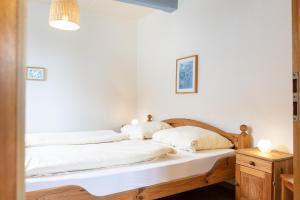 - une chambre avec 2 lits et des draps blancs dans l'établissement Ferienwohnung "Strandkorb", à Hinrichsdorf