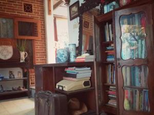 Room in BB - villas in batu indonesia homestay في Kotalama: غرفة مع رف للكتب مليئة بالكتب