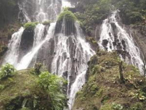 une cascade sur le côté d'une montagne dans l'établissement villas in batu indonesia homestay, à Kotalama