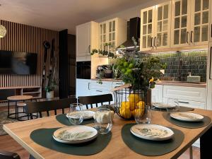 a kitchen with a wooden table with plates and wine glasses at Apartament Dzika Natura in Szczawnica