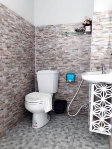 a bathroom with a toilet and a sink at Westgate Residence Hotel in Ban Bang Kho