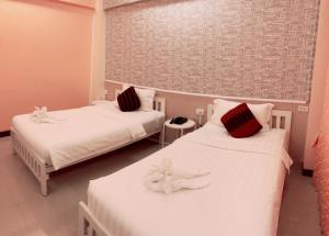 um quarto com duas camas com toalhas em Westgate Residence Hotel em Ban Bang Kho