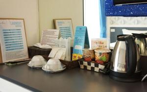 a counter top with a coffee pot and containers of food at Westgate Residence Hotel in Ban Bang Kho