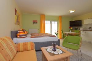 ein Wohnzimmer mit einem Bett und eine Küche in der Unterkunft Hotel Haus Orchideental Jena in Jena