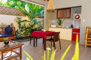 cocina y sala de estar con mesa roja y sillas en Balai sa Baibai, en Mambajao