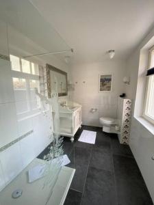 a white bathroom with a sink and a toilet at Fewo in Villa mit Seeblick in Plau am See