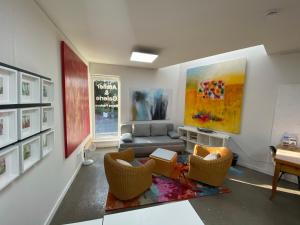 een woonkamer met een bank en stoelen en een schilderij bij Atelier-Ferienwohnung in Mülheim an der Ruhr
