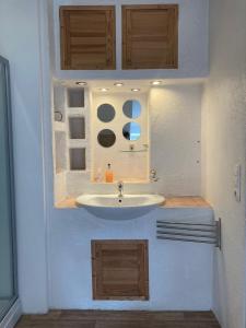 a bathroom with a white sink and wooden cabinets at Dorfschule Mollseifen in Winterberg