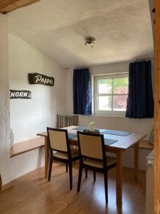 a dining room with a table and chairs and a window at Dorfschule Mollseifen in Winterberg