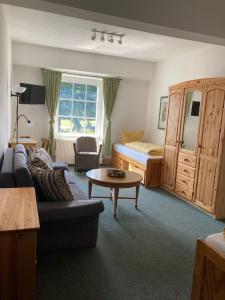 a living room with a couch and a bed at Dorfschule Mollseifen in Winterberg