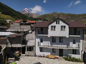 a group of buildings with mountains in the background at Kazbek view guest house in Kazbegi