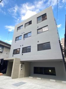 un edificio blanco alto con muchas ventanas en ART HOTELS SHIBUYA, en Tokio