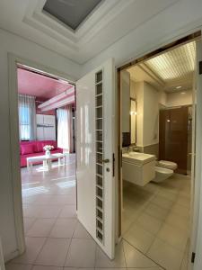 a bathroom with a door open to a bathroom with a tub at Villetta Trieste-Flexrent Abissinia in Riccione