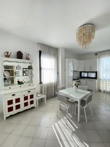 a white kitchen with a white table and chairs at Villetta Trieste-Flexrent Abissinia in Riccione