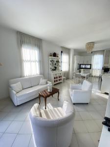 a living room with white couches and a table at Villetta Trieste-Flexrent Abissinia in Riccione