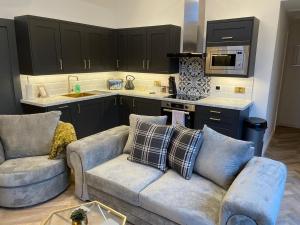 a living room with two couches and a kitchen at Cedar Lodge in Crawshaw Booth