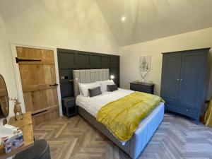 um quarto com uma cama grande e um cobertor amarelo em Cedar Lodge em Crawshaw Booth