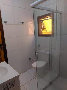 a bathroom with a toilet and a glass shower at Maresia Hostel Paraty BR in Paraty