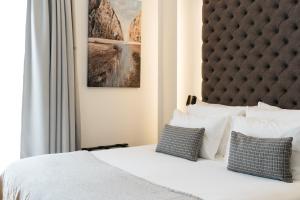 a bedroom with a white bed with two pillows at Boutique Hotel Petit Montisión in Palma de Mallorca