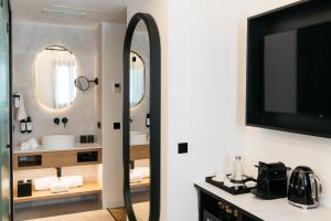 a bathroom with a large mirror and a tv at Boutique Hotel Petit Montisión in Palma de Mallorca