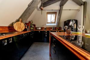 une cuisine avec des armoires noires et un comptoir en bois dans l'établissement Superbe Loft, Chalon sur Saône, à Chalon-sur-Saône