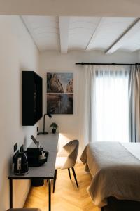 a bedroom with a bed and a desk and a window at Boutique Hotel Petit Montisión in Palma de Mallorca