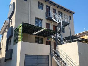 a building with a garage and stairs on it at High BnBGuestlodge in Johannesburg