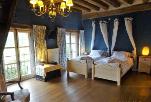 1 Schlafzimmer mit 2 Betten und einem Kronleuchter in der Unterkunft Moulin de Sévoux in Malétable