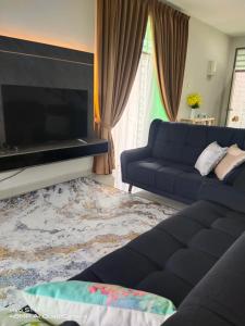 a living room with a couch and a flat screen tv at AVA Homestay Kuala Terengganu Pantai Drawbridge in Kuala Terengganu +20 photos