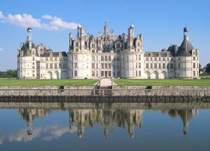 un gran castillo con su reflejo en el agua en ibis Orleans Centre Gare en Orléans