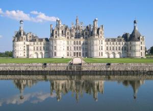 un grand château avec sa réflexion dans l'eau dans l'établissement ibis Orleans Centre Gare, à Orléans