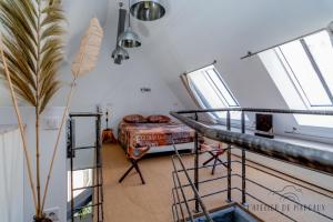 uma escada num quarto com uma cama e janelas em Superbe Loft, Chalon sur Saône em Chalon-sur-Saône
