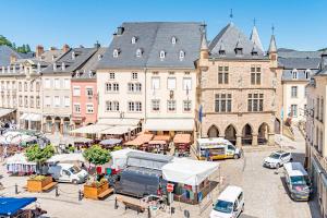 a city street with cars parked in front of buildings at H&ocirc;tel Le Petit Po&egrave;te in Echternach